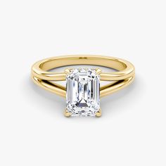 a yellow gold ring with an emerald cut diamond