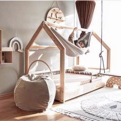 a child in a hammock hanging from a wooden frame over a white bed