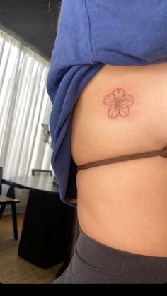 a woman with a small flower tattoo on her stomach