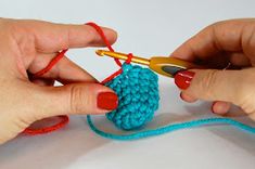 two hands crocheting the end of a ball of yarn