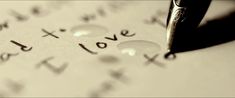 the word love written in cursive writing on a piece of paper with a pen