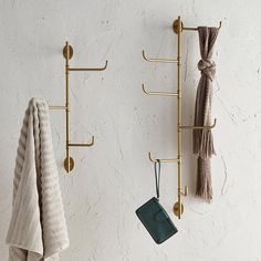 two towel racks are hanging on the wall next to each other, with hooks holding towels