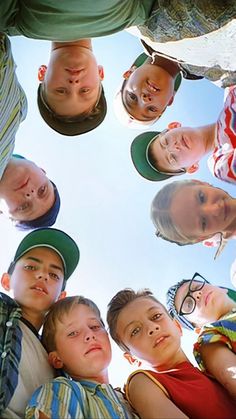 a group of kids standing in a circle looking up at the camera with their heads together