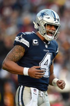 a close up of a football player wearing a uniform and holding a ball in his hand