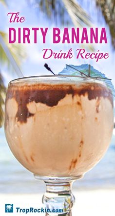 the dirty banana drink recipe is ready to be served in a glass on the beach