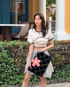 a woman is walking down the street carrying a purse