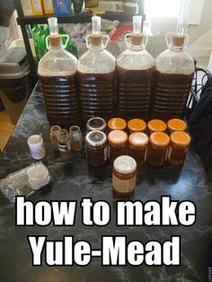 there are many bottles on the table with some liquid in them and one is labeled how to make yule - mead