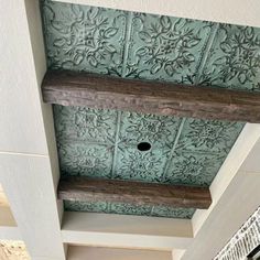 the ceiling is decorated with decorative tiles and wood beams, along with an ornate pattern