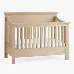 a wooden crib with white sheets on the bottom and side rails, against a white background