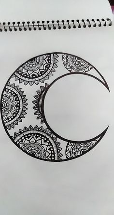 a spiral notebook with a drawing of a crescent moon on the cover, in black and white