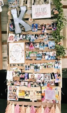 a wooden pallet filled with pictures and letters on top of a wall covered in photos