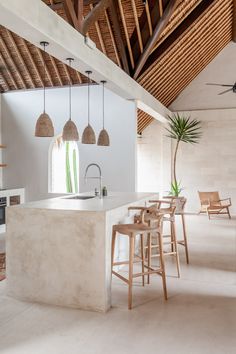 a kitchen with an island and stools next to it in the middle of a room