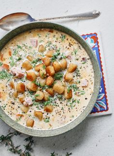 a bowl filled with soup and garnished with parsley next to a spoon