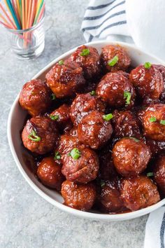 a white bowl filled with meatballs covered in sauce