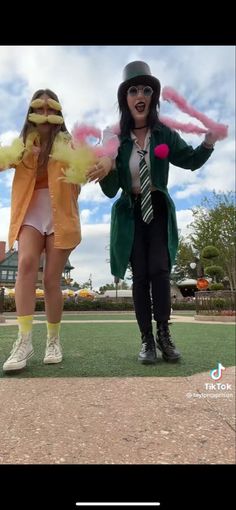 two women dressed in costumes standing on top of a field