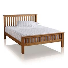 a wooden bed frame with white sheets and pillows on it's headboard, in front of a white background