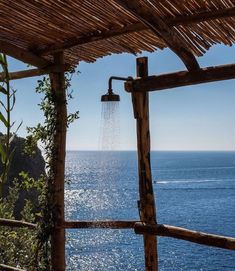 an open air shower in front of the ocean