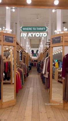 the inside of a clothing store with wooden floors and large mirrors on each side of the room