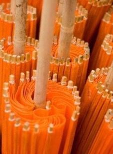 many orange wires are lined up together in this close - up photo, with the white poles sticking out to the side