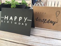 a happy birthday card sitting on top of a table next to a potted plant