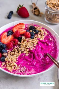 a bowl filled with fruit and granola on top of a table