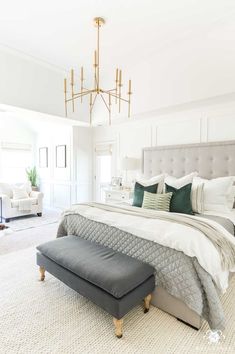 an instagramted photo of a bedroom with white walls and gray bed linens