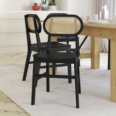 a dining room table with two chairs and a white rug on the floor in front of it