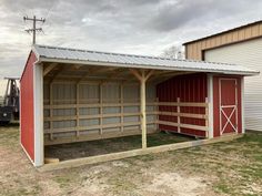 a red and white barn with a metal roof