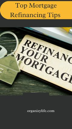 a keychain and keys on top of a desk next to a sign that says refinancing your mortgage