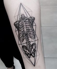 a black and white photo of a skeleton tattoo on the right arm with geometric shapes around it