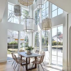 the dining room table is surrounded by chairs and chandeliers that hang from the ceiling