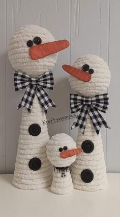 three snowmen made out of crochet sitting next to each other