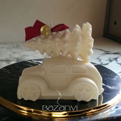 a white car with a red bow on it's top sitting on a marble table