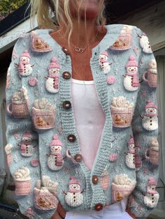 a woman wearing a blue sweater with pink and white knitted snowmen on it