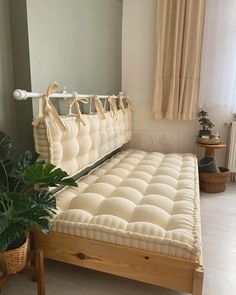 a bed with no sheets in a room next to a potted plant and window