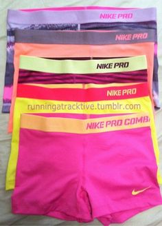 the nike pro shorts are lined up on top of each other in pink, yellow and blue