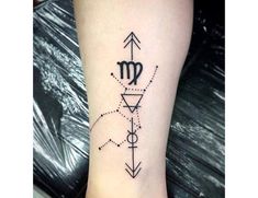 a black and white photo of a tattoo on the leg with an arrow, compass and other symbols