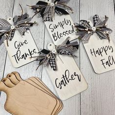 four wooden tags with sayings on them sitting on a table next to cutting boards