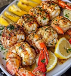 a white plate topped with shrimp and lemon wedges