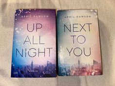 two books sitting on top of a bed next to each other