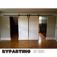 an empty room with sliding doors and hard wood flooring