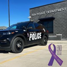 a police car parked in front of a building with a ribbon on it's side