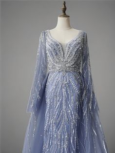 Step into a world of grace and glamour with this Elegant Light Blue Sequin Evening Gown with Tulle. The meticulously detailed sequin embellishments flow gracefully from the deep V-neckline to the hem, creating a breathtaking visual effect. This gown features long, flowing sleeves that add a touch of sophistication and provide a modest yet elegant look. The tulle overlay adds an ethereal quality, making this dress perfect for any special occasion where you want to shine. Deep V-neckline: Enhances your neckline and adds a touch of allure. Intricate sequin detailing: Ensures you sparkle from every angle. Long flowing sleeves: Add elegance and provide coverage for a sophisticated look. Tulle overlay: Adds a whimsical and ethereal touch to the gown. Be the center of attention and exude confiden Simple Satin Wedding Dress, Nontraditional Wedding Dress, Wedding Dresses High Low, Champagne Evening Dress, Ethnic Dresses, Flowing Sleeves, Fairy Wedding Dress, Sequin Evening Gowns, Gothic Wedding Dress