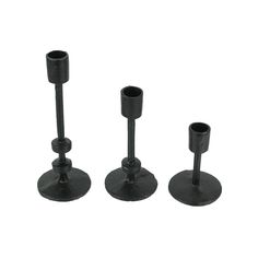 three black candlesticks and one candle holder