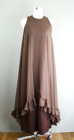 "This is a head-turner. It is a brown polyester sheath with a sheer chiffon overlay that features a high-low hemline. It is in excellent ready to wear condition. Estimated size S 34\" bust 28\" waist 38\" hip 54\" nape of neck to hem Purveyor's Note: We have searched far and wide, wrestled bears, braved the cold, traversed mountain ranges, fought pirates, swam with sharks and eaten at many a questionable road side taco stand to provide our customers with one of a kind vintage pieces. Know that w Black Tie Party Dress, Taco Stand, Black Tie Party, Embroidered Bird, Chiffon Overlay, Cocktail Gowns, Nape Of Neck, Mountain Ranges, Sheer Chiffon