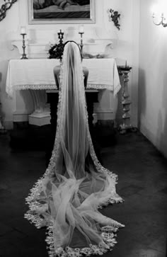 a veil draped over the back of a woman's dress in front of a dining room table