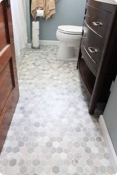 a bathroom with a toilet, sink and wooden cabinet in the corner next to it