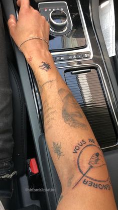 a person with a tattoo on their arm in a car