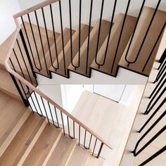 a wooden staircase with black railing and handrails