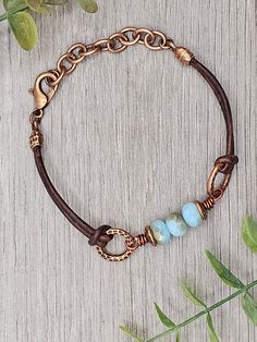 Czech Glass Aqua Opal Celsian beads with antique copper accents on antique brown leather bracelet.  This bracelet has a size fit of approximately 7 inches to 7 1/2 inches. To keep beads, leather and all other components looking their best, avoid contact with water, lotions and perfumes. To access all other items in my shop, just hit the link here: https://www.etsy.com/ca/shop/KootenayLeatherRHS If you like jewelry, check out my other Etsy shop...it's jewelry for your door!  www.etsy.com/ca/shop/ Adjustable Brown Jewelry With Patina, Adjustable Brown Patina Jewelry, Handmade Adjustable Vintage Brown Jewelry, Adjustable Rustic Bronze Bracelets, Rustic Adjustable Bronze Bracelets, Rustic Adjustable Bronze Bracelet, Patina Brown Bracelet Jewelry, Brown Patina Bracelet Jewelry, Brown Copper Bracelet With Patina